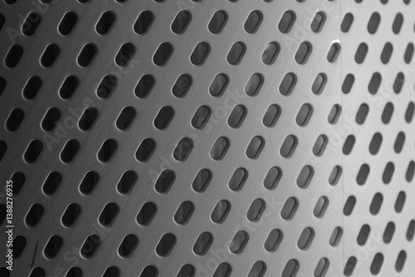 Obraz Textured metal surface featuring circular perforations with varying sizes and shadows creating a modern industrial aesthetic