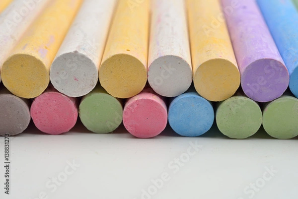 Obraz Pieces of chalks in a variety of colors arranged in lines on a white background. Back to school,education, arts, creative. Image with room for text