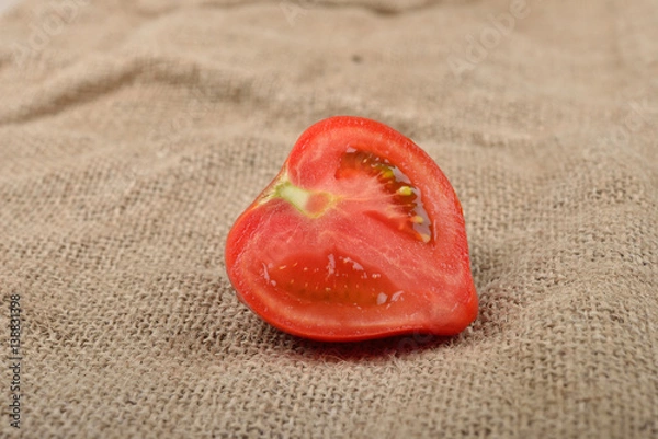 Obraz Fresh red tomato cut in half on jute canvas. Healthy nutrition