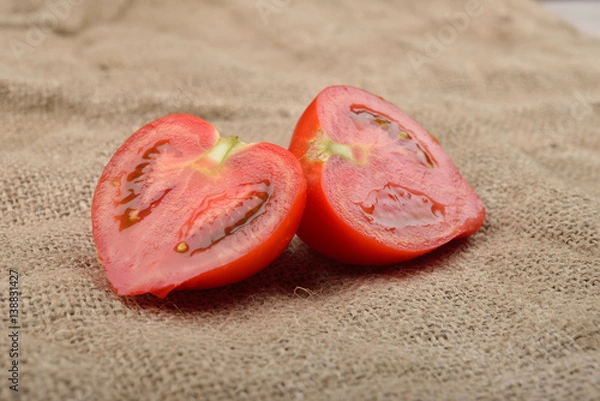 Obraz Fresh red tomato cut in half on jute canvas. Healthy nutrition