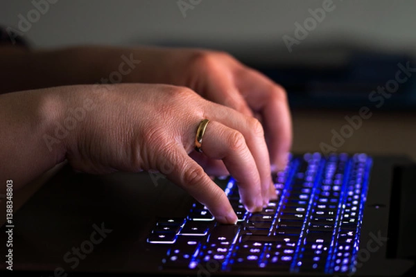Fototapeta Close-up of a woman's hands with the backlight of a laptop keyboard, backlit keyboard