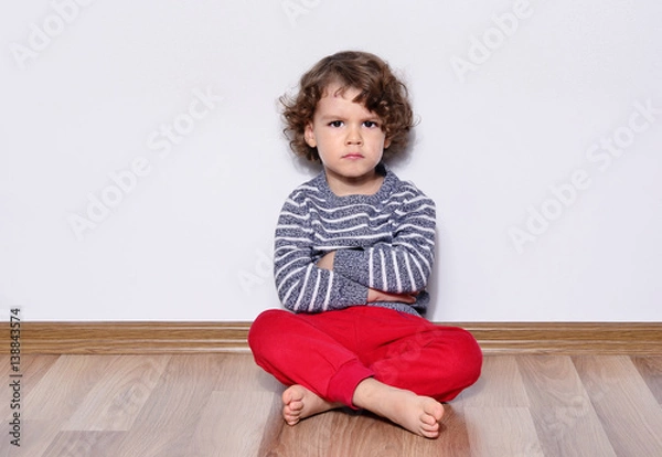 Fototapeta Beautiful angry boy looking at you. Mad kid got upset and sad and he has a negative attitude. Depressed boy  complaining 