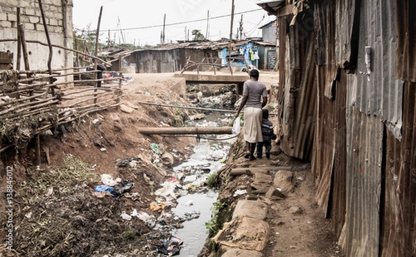 Fototapeta Ludzie idący otwartym kanałem w slumsach w Afryce