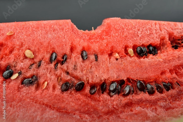 Obraz Close up of fresh watermelon with bunch of seeds with a bite isolated on black background