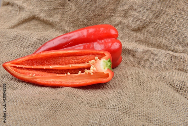 Obraz Half of red pepper lying on on sackcloth background. Concept of healthy food, bio from countryside