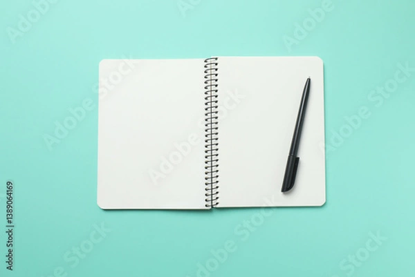 Obraz Top view photo of notebook with a pen on color background with blank space. Business concept