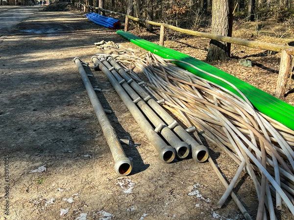 Fototapeta Pipes and equipment used to build a sanitary sewage system stored at the construction site