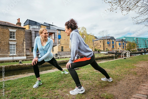Obraz Two girls doing stretching exercises outdoors in London