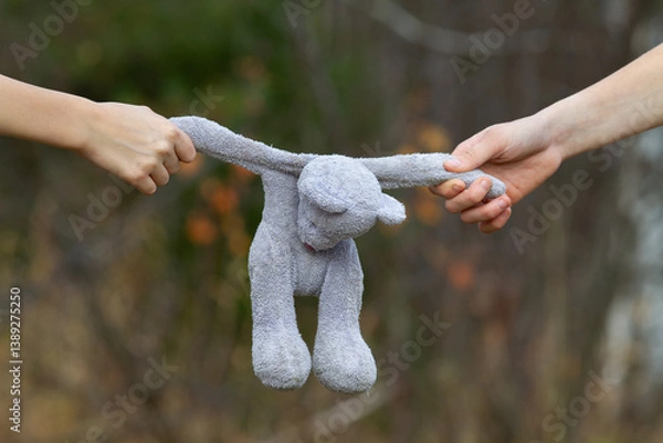 Obraz hands of children snatching a teddy bear from each other