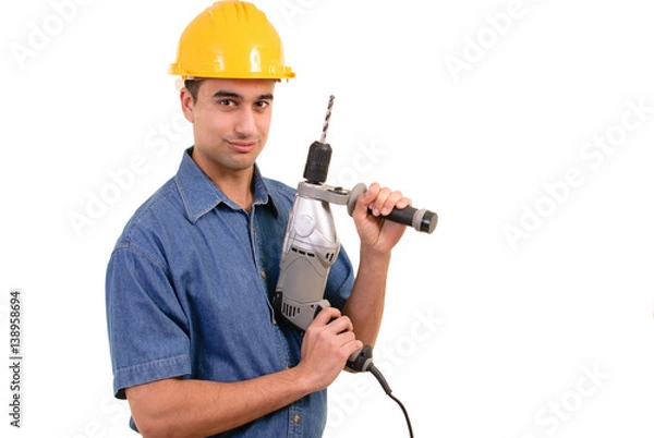 Fototapeta Junger Bauarbeiter mit Bohrmaschine