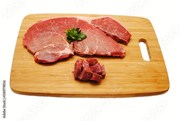 Fototapeta Cutting a Raw Steak on a Wooden Cutting Board