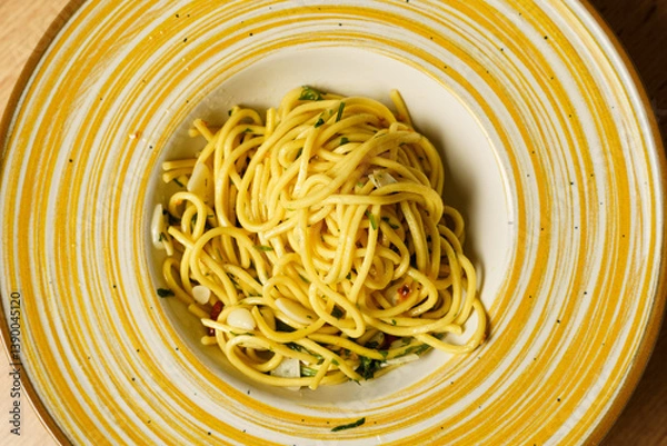 Obraz Close-up of plated spaghetti aglio e olio on a wooden table