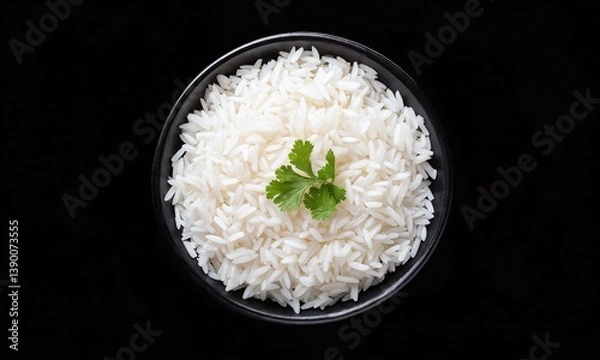 Obraz Bowl of fluffy white rice garnished with fresh cilantro on a contrasting black background
