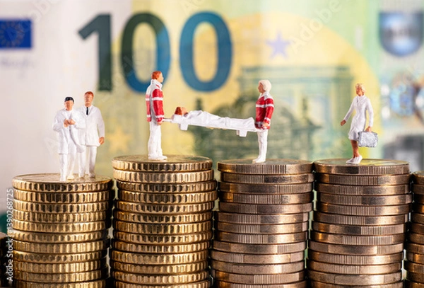 Fototapeta Figures from the healthcare sector on stacks of money in front of a one hundred euro bill