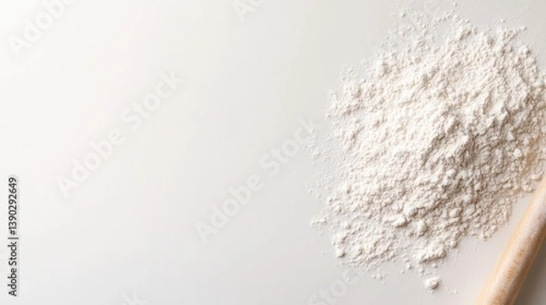 Fototapeta Powdered flour spread across clean surface with wooden spoon nea