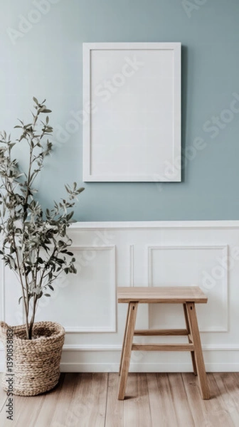 Fototapeta Minimalist Living: A serene interior featuring a blank frame, a potted plant, and a wooden stool, bathed in soft, natural light, creating a calming and inviting atmosphere.