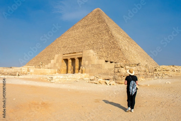 Fototapeta Back view of Young woman taking picture of Great Sphinx and Great Pyramid of Cheops, Cairo, Egypt. Ancient statue of Sphinx, mythical creature with head of man and body of a lion