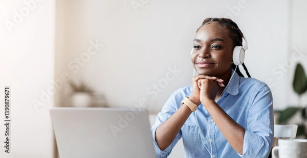Fototapeta Break At Work. Relaxed African American Female Employee Listening Music In Headphones At Workplace In Office, Sitting At Desk With Laptop Computer And Looking Away, Resting Chin On Hands, Copy Space