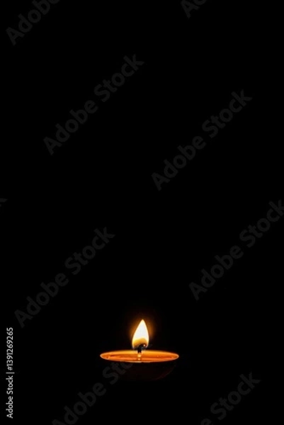 Obraz Single candle flame against black background