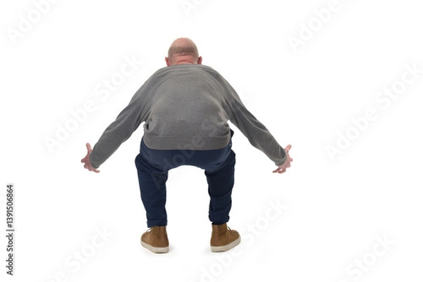 Fototapeta back view of a man lifting something heavy from the ground on white background
