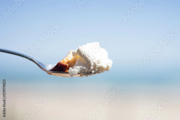 Obraz metal silver spoon with cream and custard in background blue like beach. copy space, no people