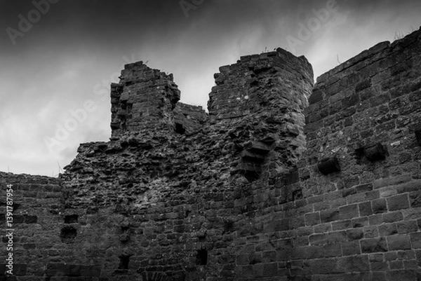 Fototapeta Ancient stone ruins stand against a moody sky in a historic site during twilight hours
