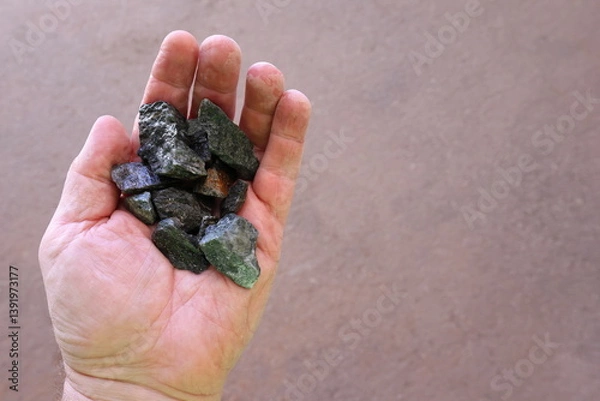 Fototapeta Scheelite ore held in hand. Mined for tungsten (wolfram), used to produce tungsten carbide, alloys and steels, hard permanent magnets, ammunition designed to penetrate vehicle armor in war