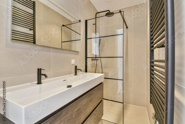 Fototapeta A sleek and contemporary bathroom showcasing a stylish sink with elegant faucets, a glass shower enclosure, and minimalist decor for a clean aesthetic.