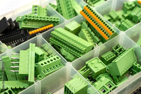 Fototapeta Screw terminal blocks. Components for electrical equipment. Terminal blocks inside plastic container. Cells with connectors for boards. Screw terminal blocks of different types. Wire connectors