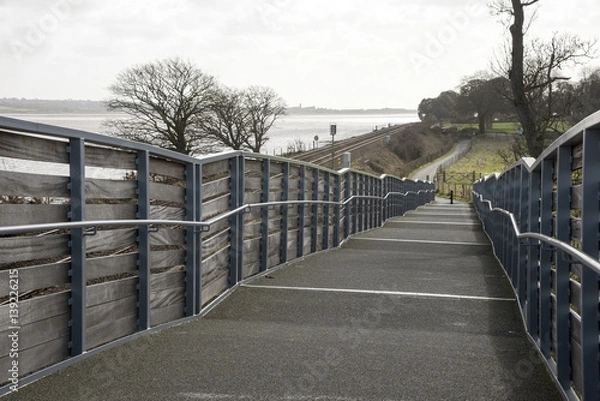 Fototapeta Cycleway and pedestrian foothpath acrooss rail lines to the Exe Estuary footpath near Starcross in South devon England UK