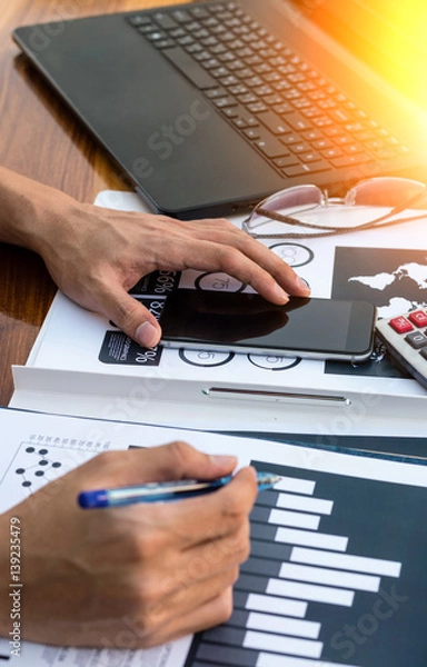 Fototapeta Business workers discussing digital graphs and diagrams indicating progres.