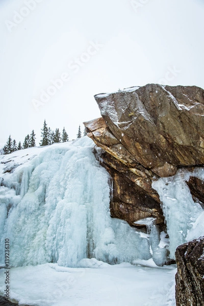 Fototapeta A beautiful landscape of a frozen waterfall in the snowy Norwegian winter day
