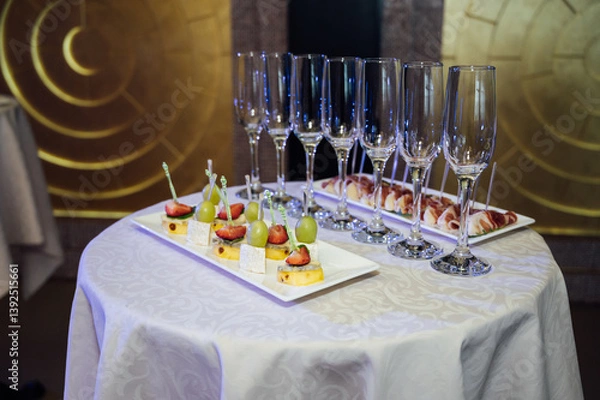 Fototapeta Appetizer Plate. An area for welcoming guests with food and empty champagne glasses