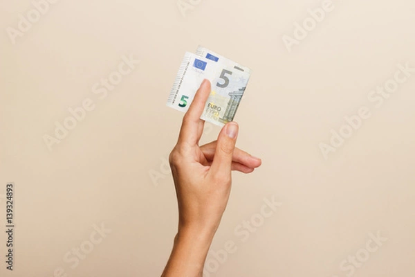 Fototapeta Woman's hand with money on a light background