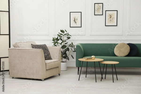 Fototapeta Stylish living room interior. Comfortable sofa, armchair and nesting tables indoors