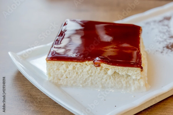 Fototapeta Milk dessert with caramel trilece served on a plate