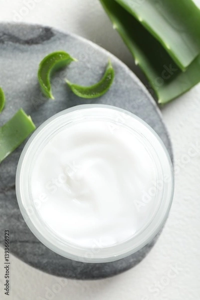 Fototapeta Cream and aloe leaves on white background, flat lay