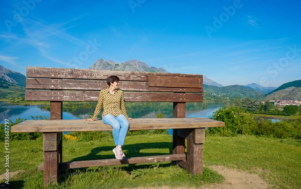 Fototapeta Woman on top of the highest bench in the León communi