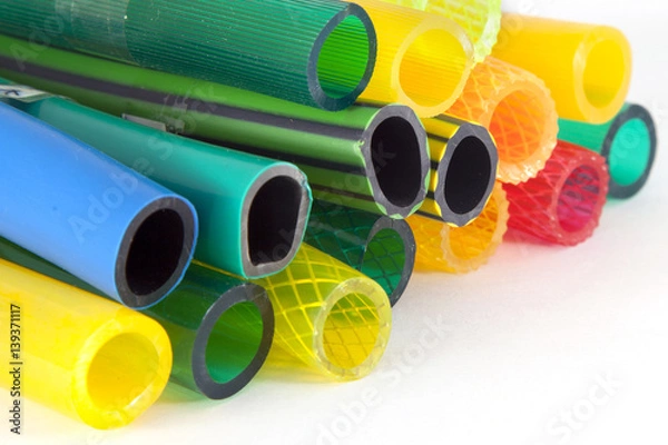 Obraz colorful plastic gardening hoses on white background