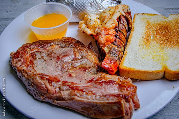 Fototapeta steak and lobster plate with butter cup and toast