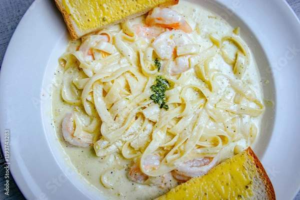 Fototapeta Top view of shrimp and pasta with white sauce served with slice of toast bread 