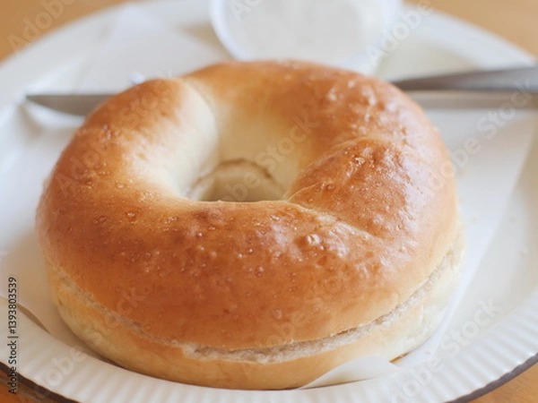 Fototapeta Bagel with cream cheese. Classic Baked Bagel bread serving on the plate. Famous quick and easy flour breakfast menu in restaurant.