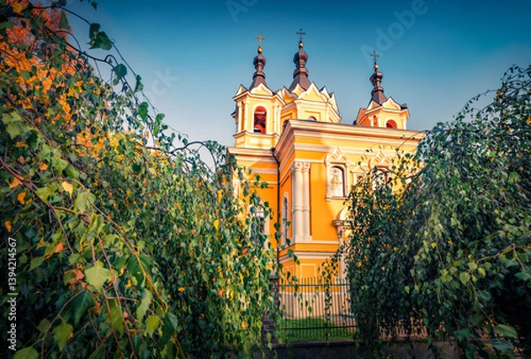 Obraz Beautiful morning view of Orthodox Church of St. Nicholas the Wonderworker among the birch branches. Nice summser cityscape of Tomaszow Lubelski town, Poland. Traveling concept background.