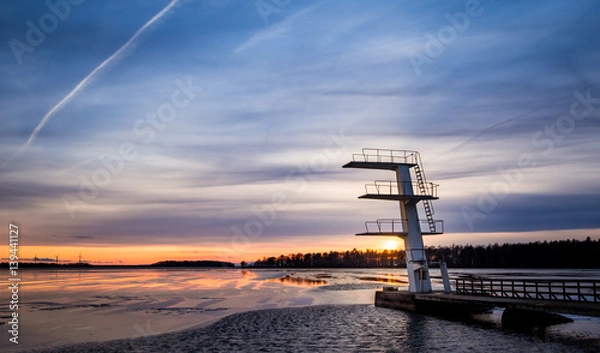 Obraz Diving tower at sunset in winter with ice on lake