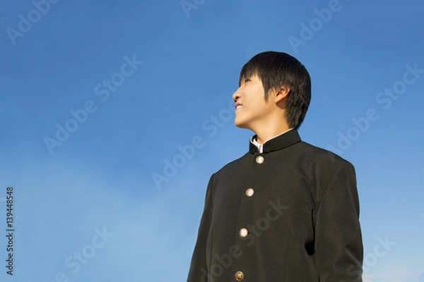 Fototapeta 青空バックに遠くを見つめる高校生男子