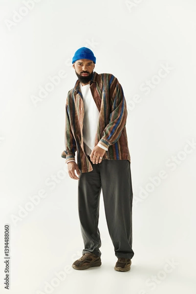 Fototapeta Stylish young man showcases unique fashion sense with modern flair in a minimalist setting