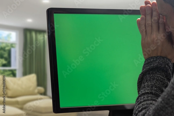 Fototapeta Closeup of upset depressed man searching problem solution and praying during work. Frustrated man at a computer monitor with a chromakey background, showcasing the emotional struggle with tech issues