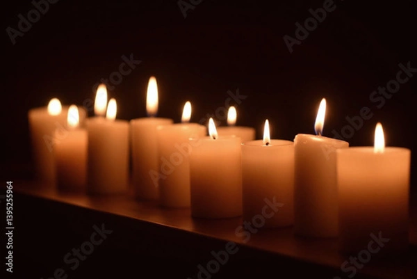 Fototapeta group of lit candles sitting on top of a table