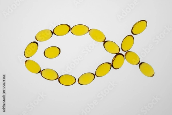 Fototapeta Omega 3 yellow capsules lying in the form of the fish, supplement and health support concept