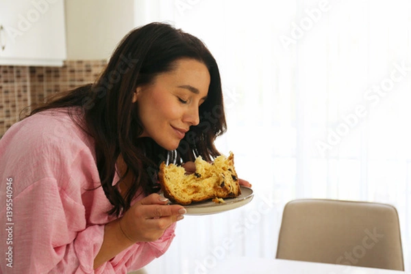 Obraz Brunette woman enjoying her panettone cake on Easter Sunday. Copy space, background.